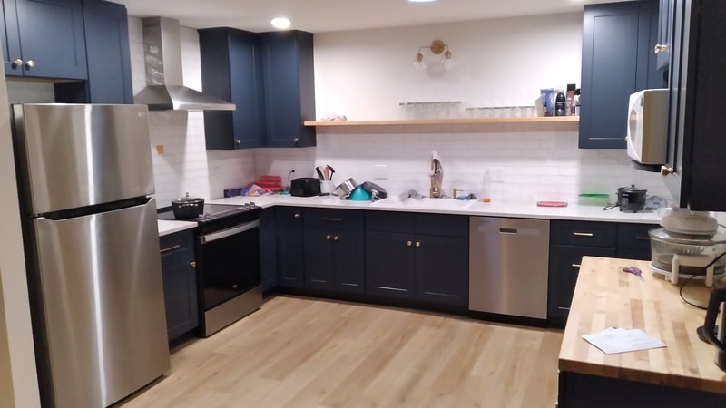 Kitchen with navy blue cabinets and stainless steel appliances in House 2
