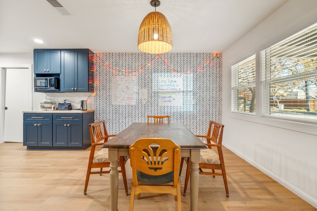 Kitchen and dining area with navy blue cabinets and herringbone wallpaper in House 2