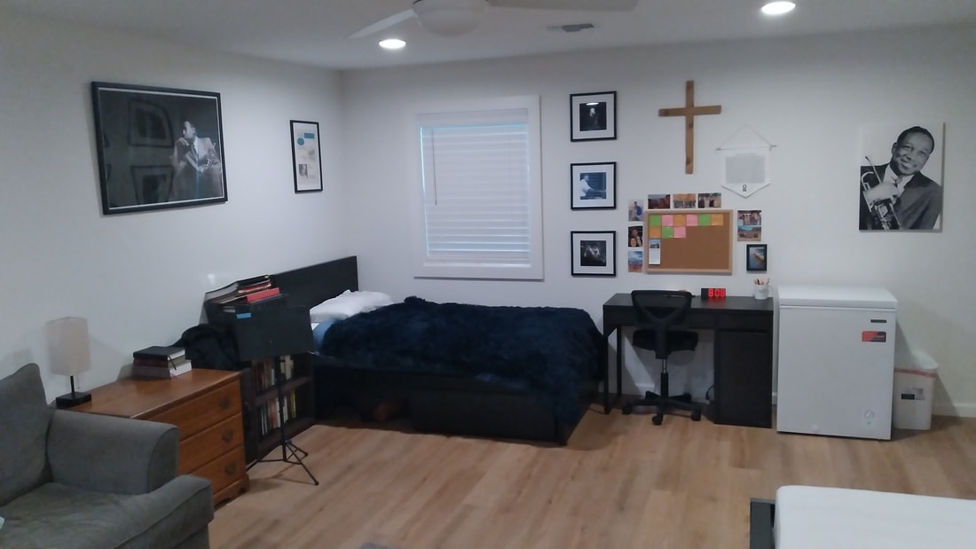 Bedroom with jazz art, wooden cross, desk and study area in House 2